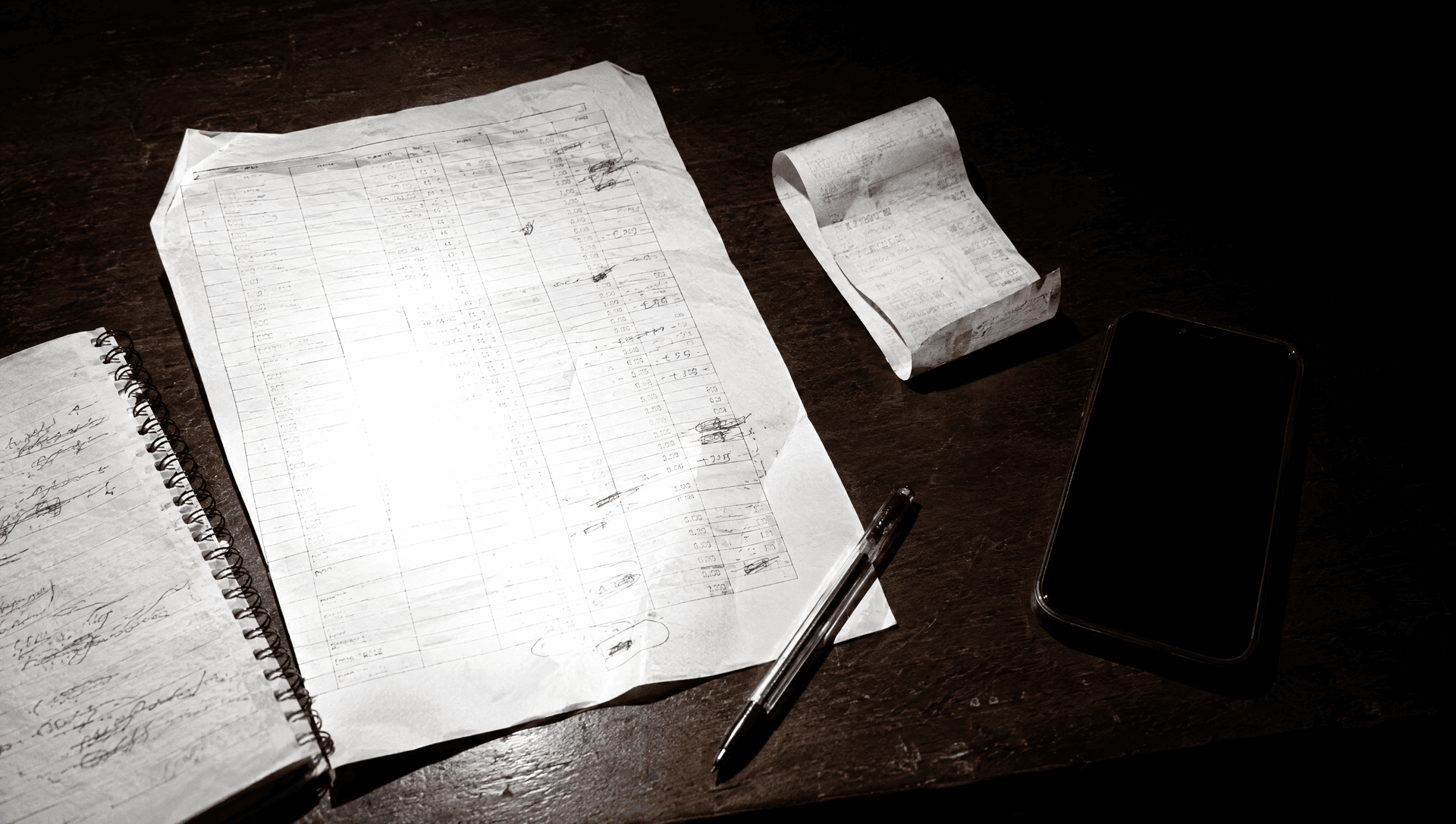 Cierre de turno escrito a mano sobre una mesa, de noche, junto a una comanda y un teléfono apagado